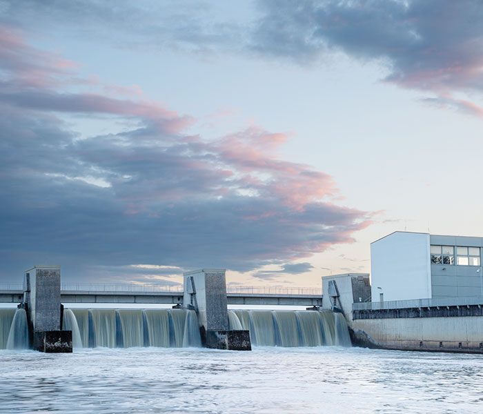 A water dam with a building in the background.