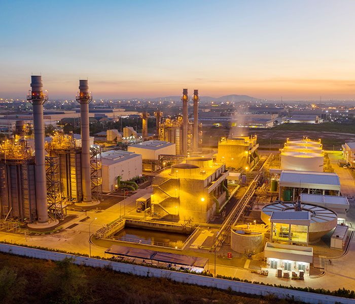 A factory with smokestacks and towers.